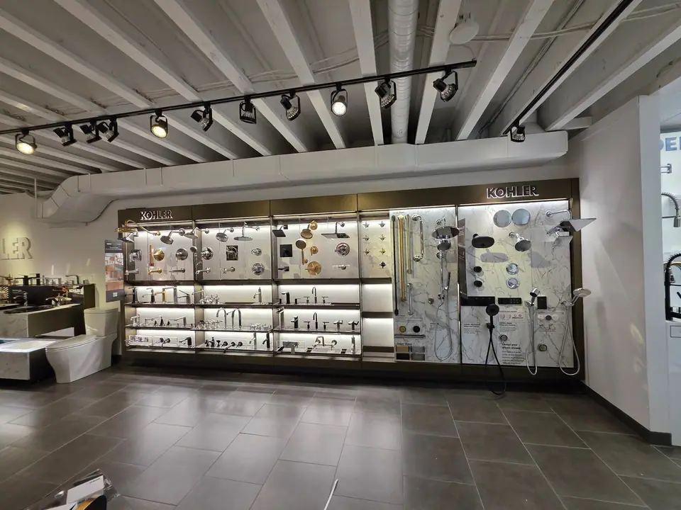 The main aisle of a KOHLER fixture showroom with tubs, sinks and lit fixture walls