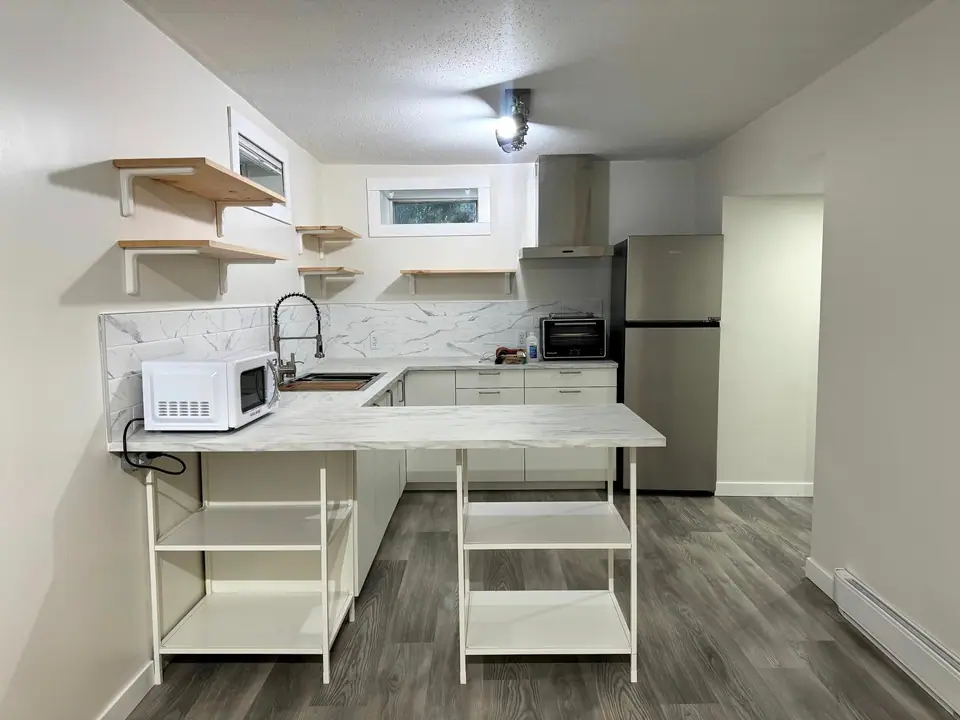 The finished suite kitchen from the side, with the fridge and peninsula